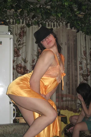 Tipsy Russian flirt poses in a silk dress and black hat